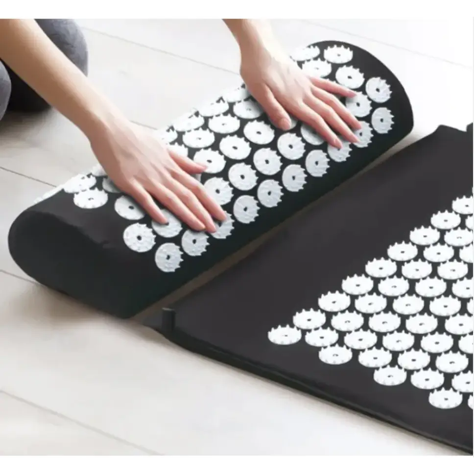 Black cylindrical and rectangular massage cushions with white circular acupuncture points.
