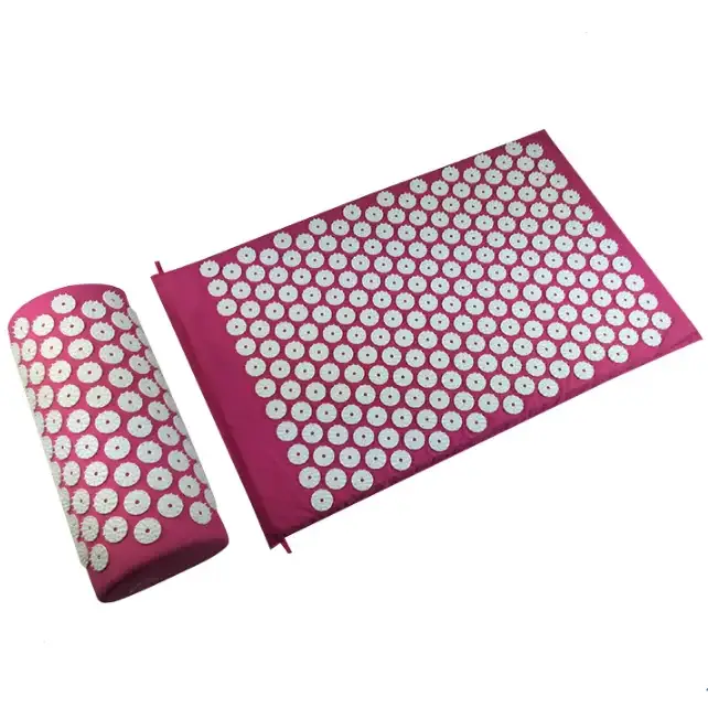 Pink acupressure mat and pillow with white circular needles.