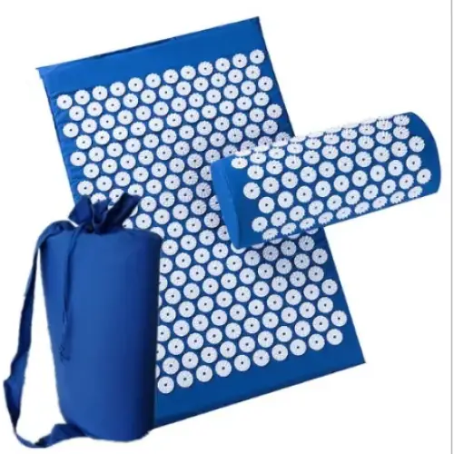 Blue acupressure mat set with white circular needles and matching cylindrical pillow, packaged in a blue drawstring bag.