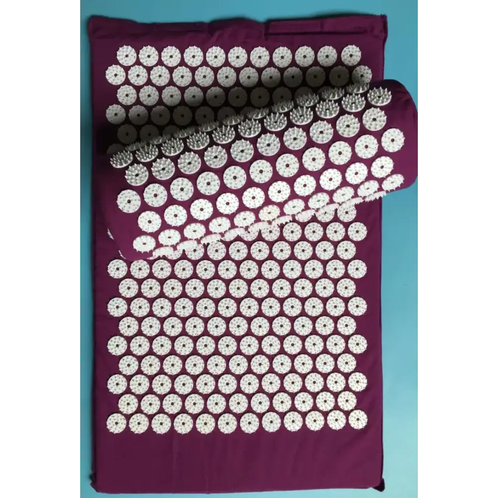 Purple acupressure mat with white circular spikes arranged in a grid pattern.
