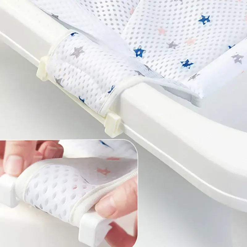 White mesh baby bath seat with star patterns in blue and gray.