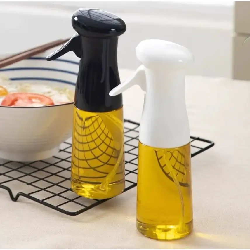 Two transparent plastic spray bottles with black and white nozzles, filled with golden-yellow oil.