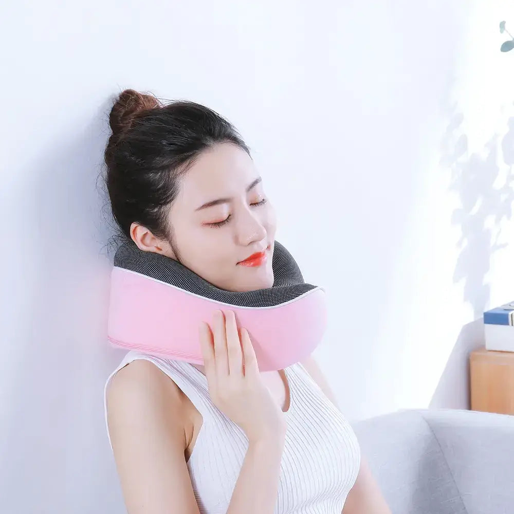 Pink and black neck massage cushion with soft, contoured design for comfort.