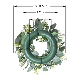 Green artificial eucalyptus wreath with white flowers.