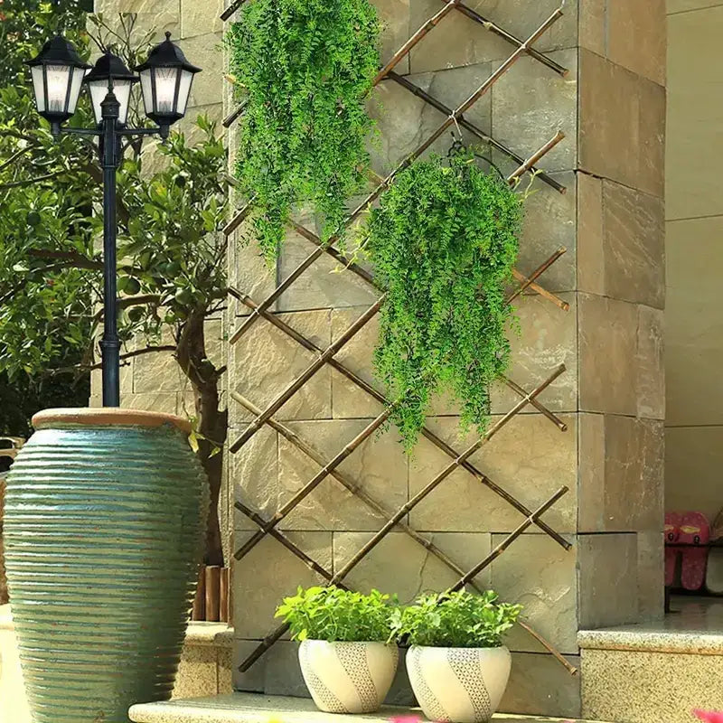 Bamboo lattice trellis with a diamond pattern, featuring natural brown bamboo poles and supporting hanging green vines.