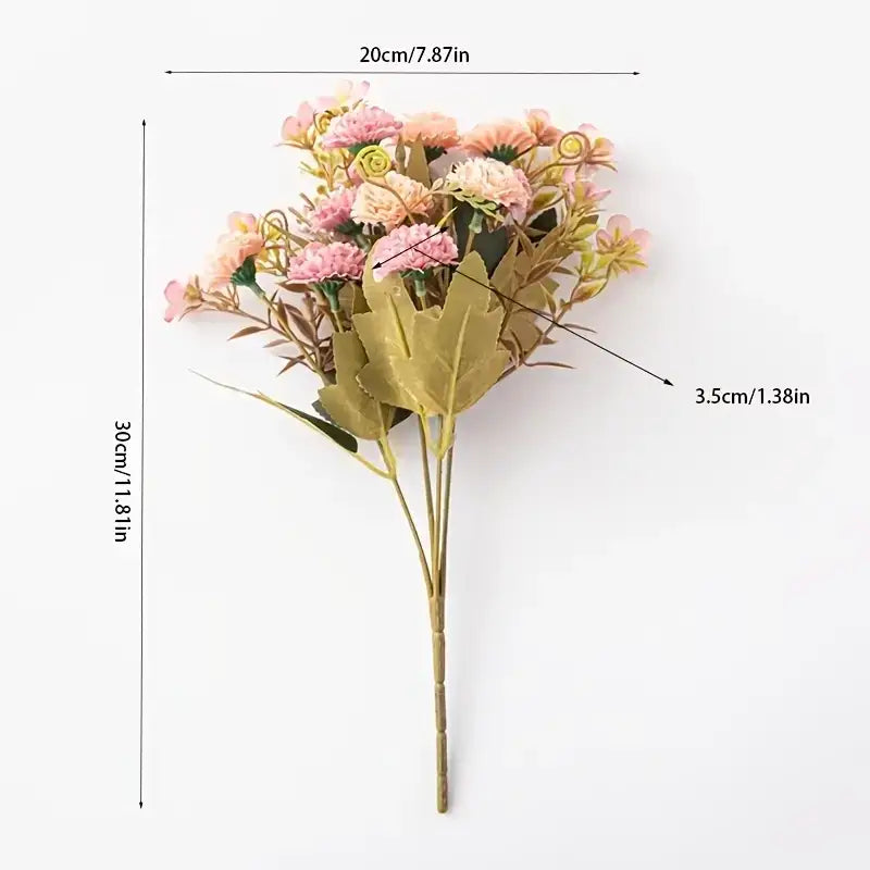 A delicate bouquet of artificial flowers in soft pink and peach hues, accented with green leaves and stems.