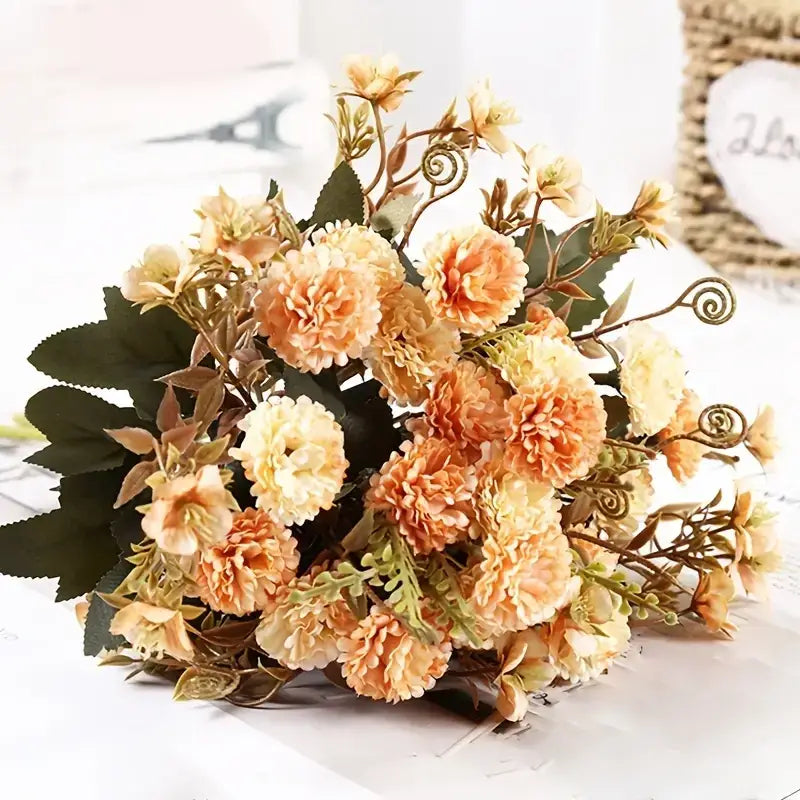 A bouquet of artificial peach and cream-colored flowers with green leaves and curly stems.