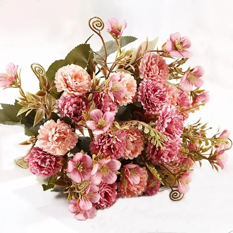 A bouquet of artificial pink and peach roses with green leaves and decorative spiral stems.