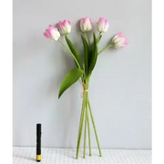 A bouquet of artificial pink and white tulips with green stems and leaves, tied together at the base.