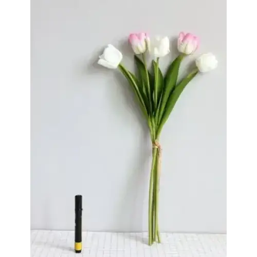 A bouquet of artificial tulips with pink and white petals, green stems tied together with twine.