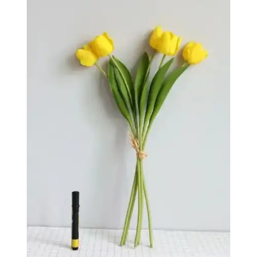 A vibrant yellow artificial tulip bouquet with green stems tied together by a natural-colored twine.