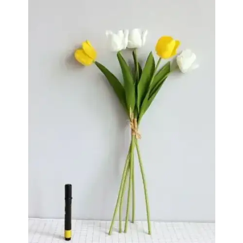 A bouquet of artificial tulips, featuring vibrant yellow and crisp white blooms with green stems tied together by a natural-colored twine.