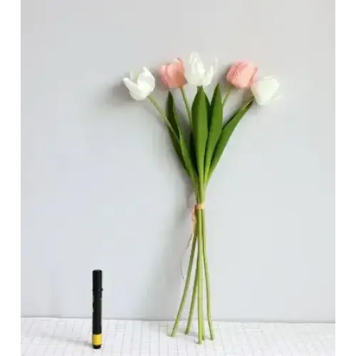 A delicate bouquet of artificial tulips, featuring soft pink and white blooms with vibrant green stems tied together by a thin ribbon.