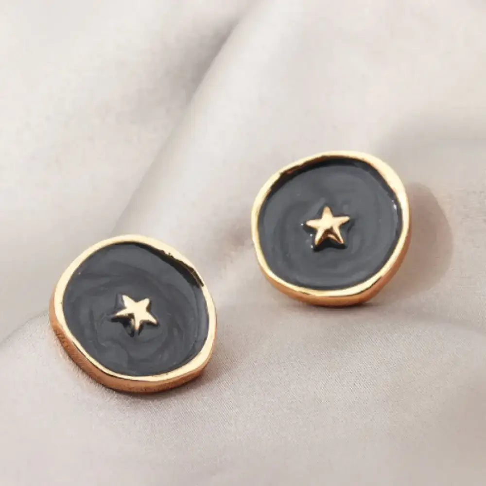 Black and gold star button earrings with a glossy finish.