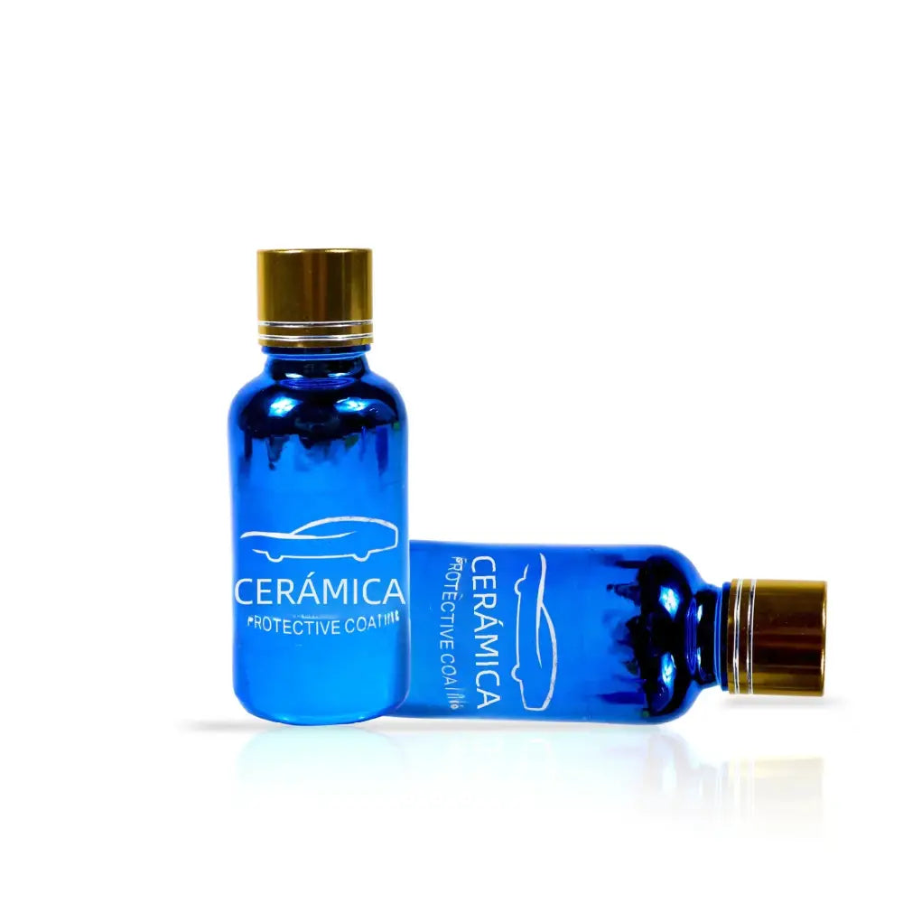 Two blue glass bottles with gold caps, labeled ’cerámica protective coat’ and featuring a white car silhouette design.