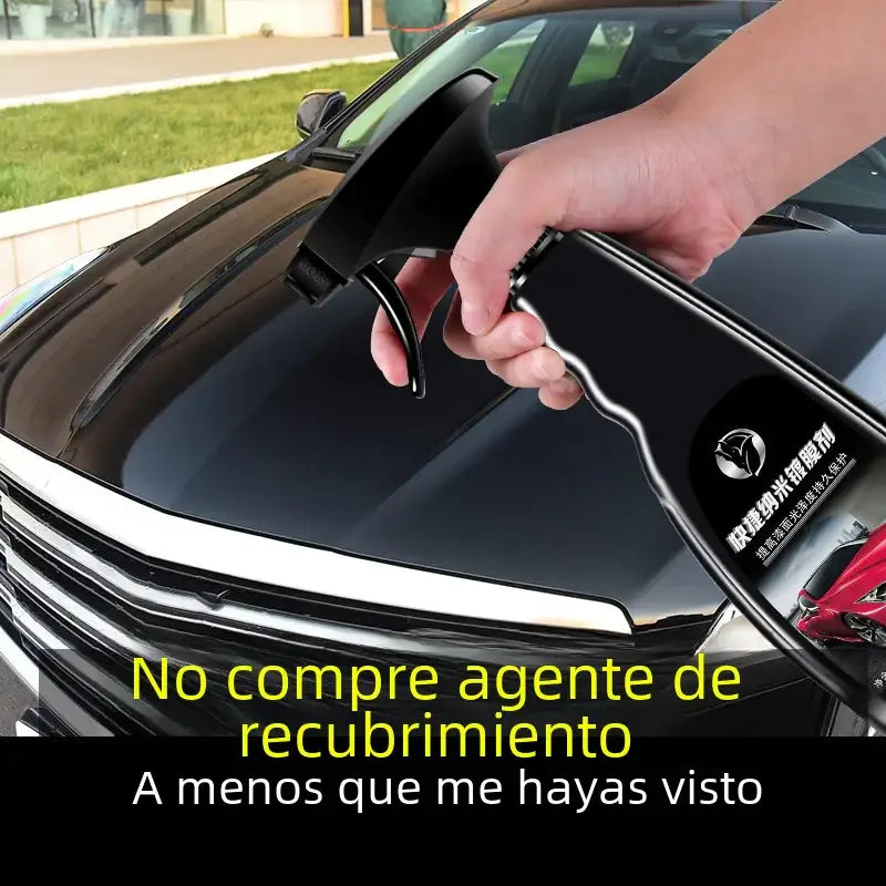 Black spray bottle with a trigger nozzle and label featuring chinese characters, being held over the hood of a black car.