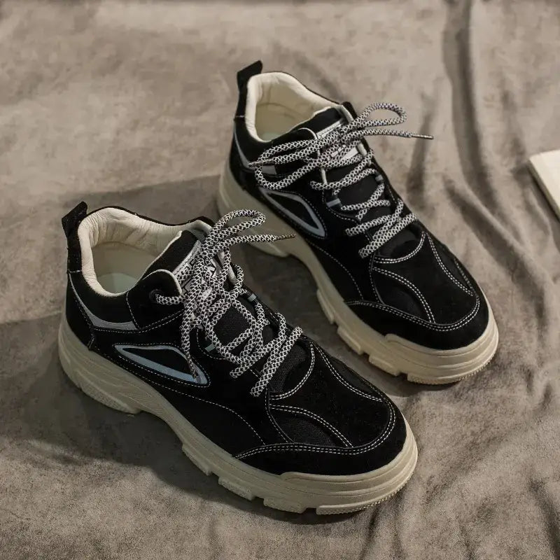 Black suede sneakers with white laces and a chunky off-white sole, featuring light blue accent panels.
