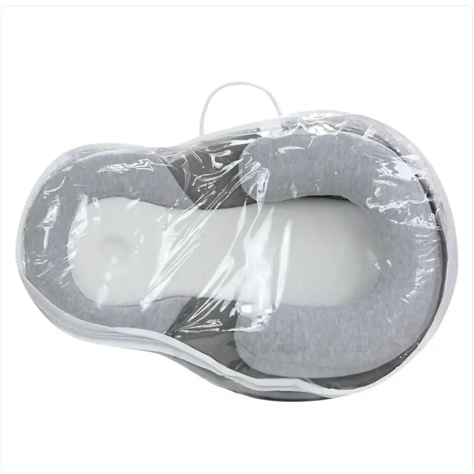 Gray and white memory foam baby sleep positioner wrapped in clear plastic.