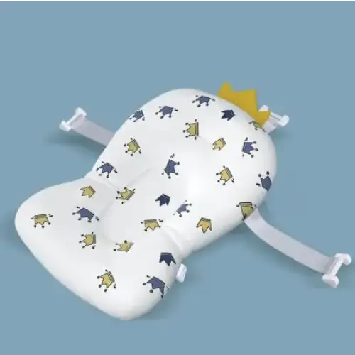 White bath seat with a playful pattern of blue and yellow crowns, featuring soft fabric material and adjustable white straps for secure placement.