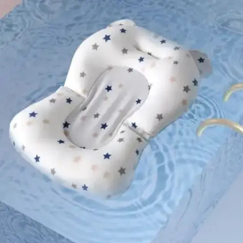 White star-patterned baby bath seat with soft, cushiony material and a gentle curve for comfort.
