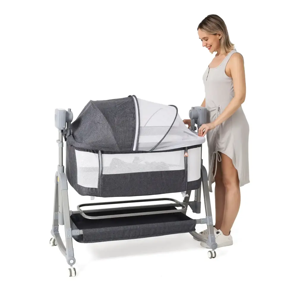 Gray and white convertible rocking baby cradle with mesh sides, wheeled base, and adjustable height.