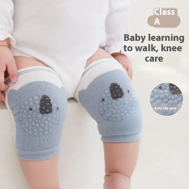 Light blue knitted knee pads with embroidered koala faces and textured, dark gray anti-slip padding.