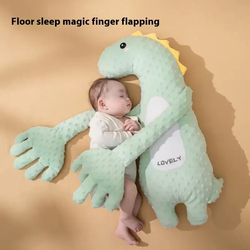 A soft, mint-green plush dinosaur floor sleep aid with a textured surface and yellow spines.