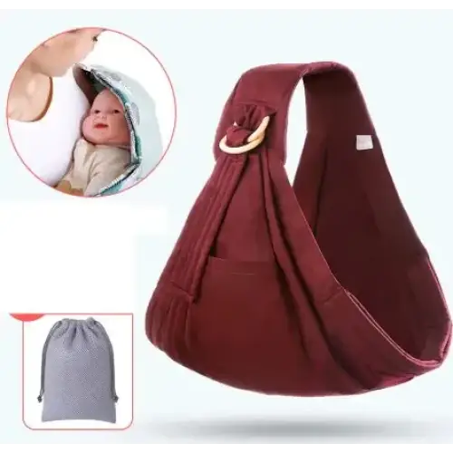 Maroon fabric baby sling with adjustable straps and a wooden ring at the shoulder strap.