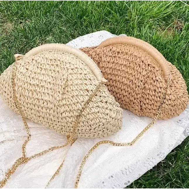 Beige and tan woven straw clutch bags with gold chain straps.