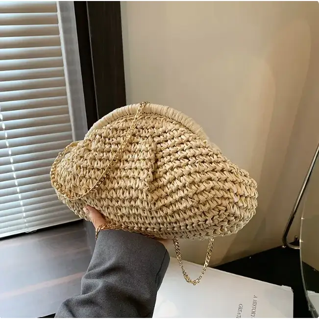 Beige woven straw handbag with a gold chain strap.