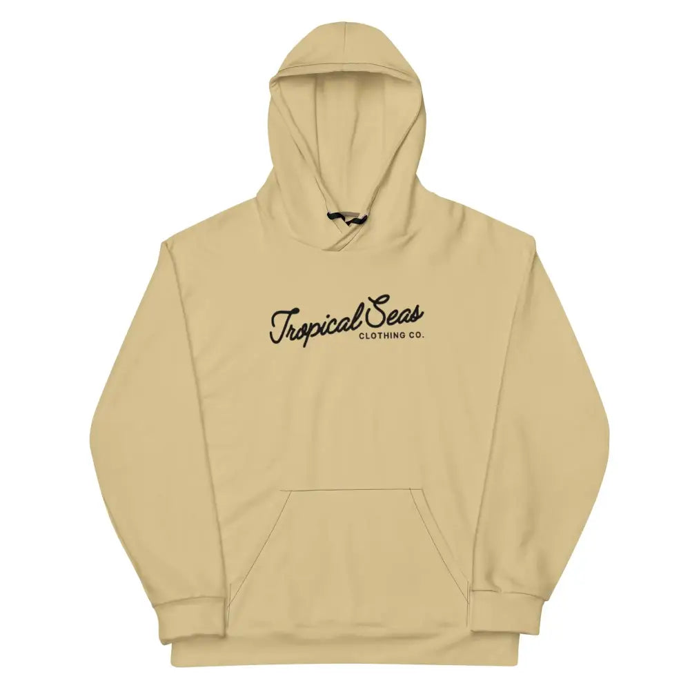 Beige hooded sweatshirt with black cursive ’tropical seas’ and smaller text below, featuring a front kangaroo pocket.