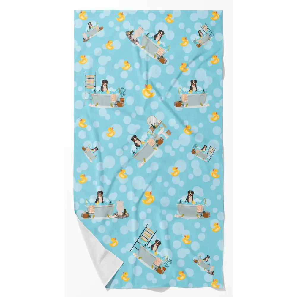 Light blue blanket featuring a repeating pattern of australian shepherds in bathtubs surrounded by yellow rubber ducks and white polka dots.