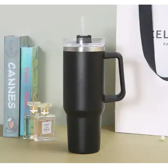 Black insulated travel mug with a stainless steel lid and handle.