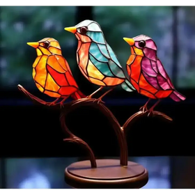 Vibrant stained glass birds in orange, teal, and pink perched on a bronze branch base.