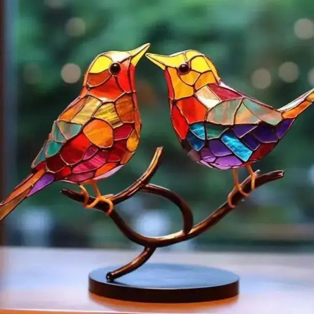 Vibrant stained glass birds perched on a curved branch, crafted with colorful mosaic panels and set upon a dark wooden base.
