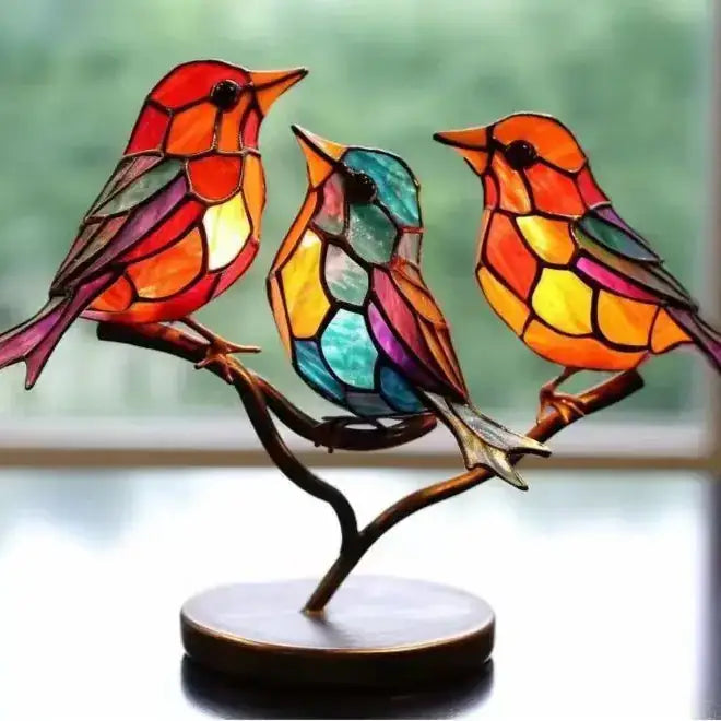 Vibrant stained glass bird figurine set with colorful, segmented wings and bodies perched on a curved branch base.