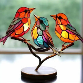 Vibrant stained glass bird figurine set with colorful, segmented wings and bodies perched on a curved branch base.