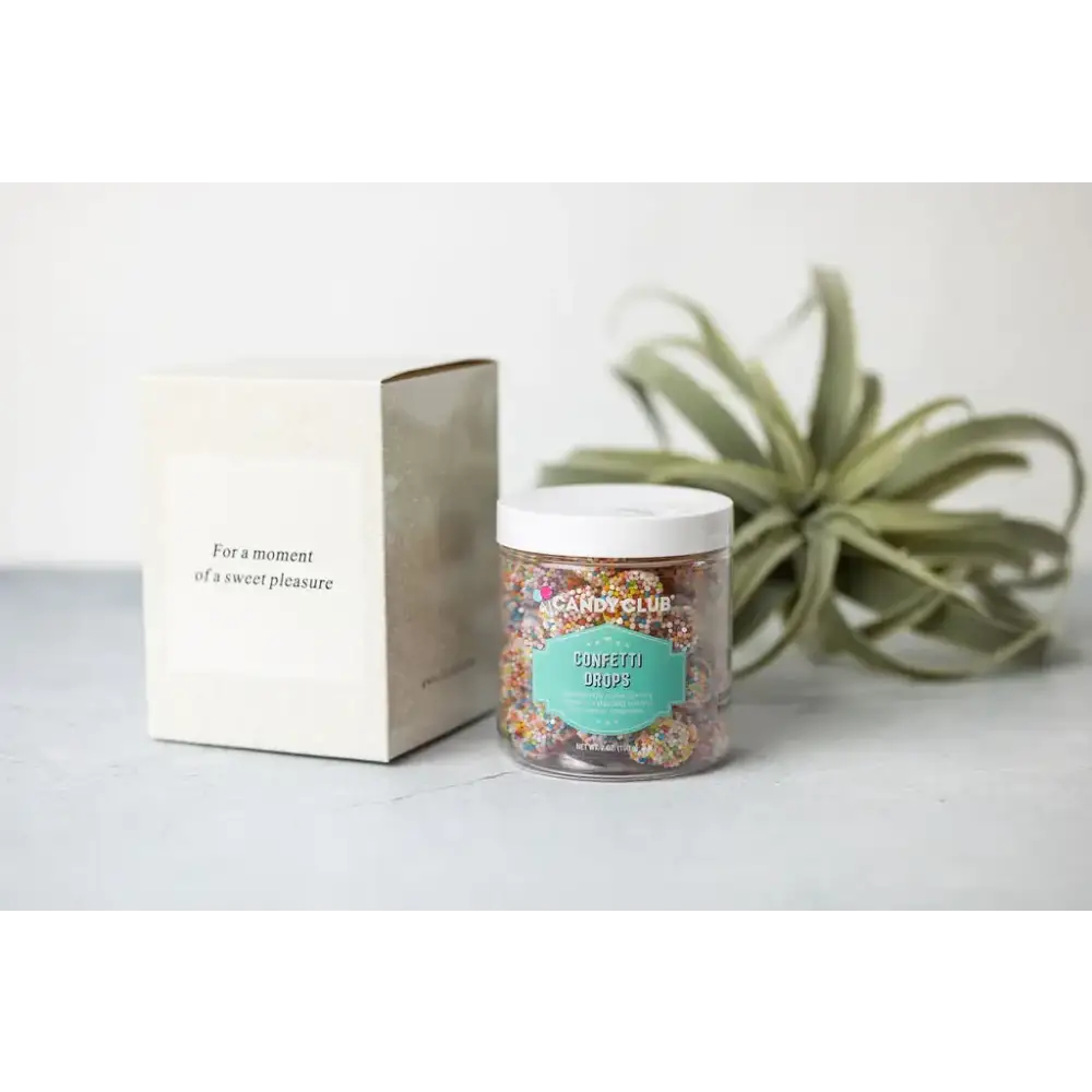 A clear glass jar with a white lid, filled with colorful confetti drops candy from candy club.