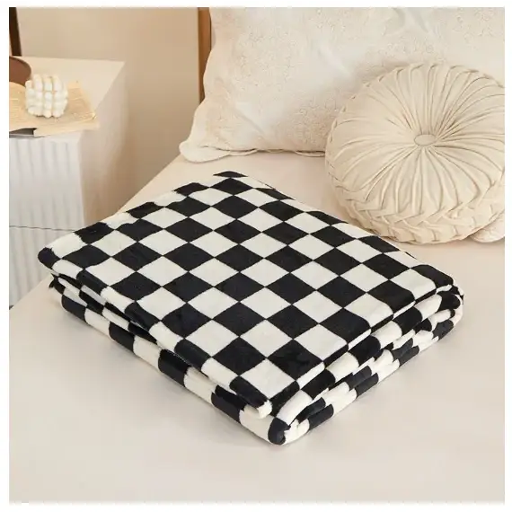 A plush black and white checkered throw blanket with a soft, textured surface.