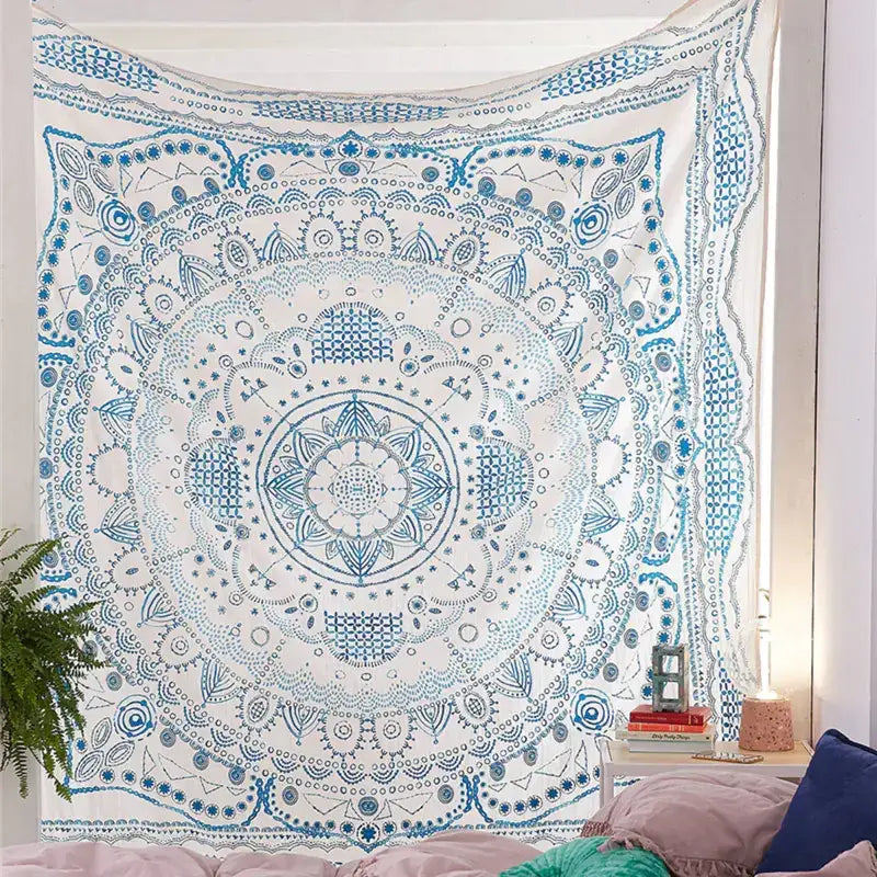 A white and blue mandala tapestry with intricate geometric patterns hanging on a wall.