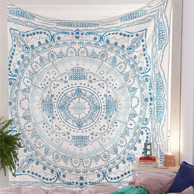 A white and blue mandala tapestry with intricate geometric patterns hanging on a wall.