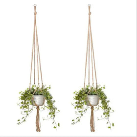 Natural fiber macrame plant hangers with white ceramic pots holding trailing green ivy.