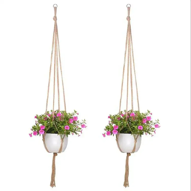 Two beige macrame hanging planters, each holding a white ceramic pot with pink flowering plants.