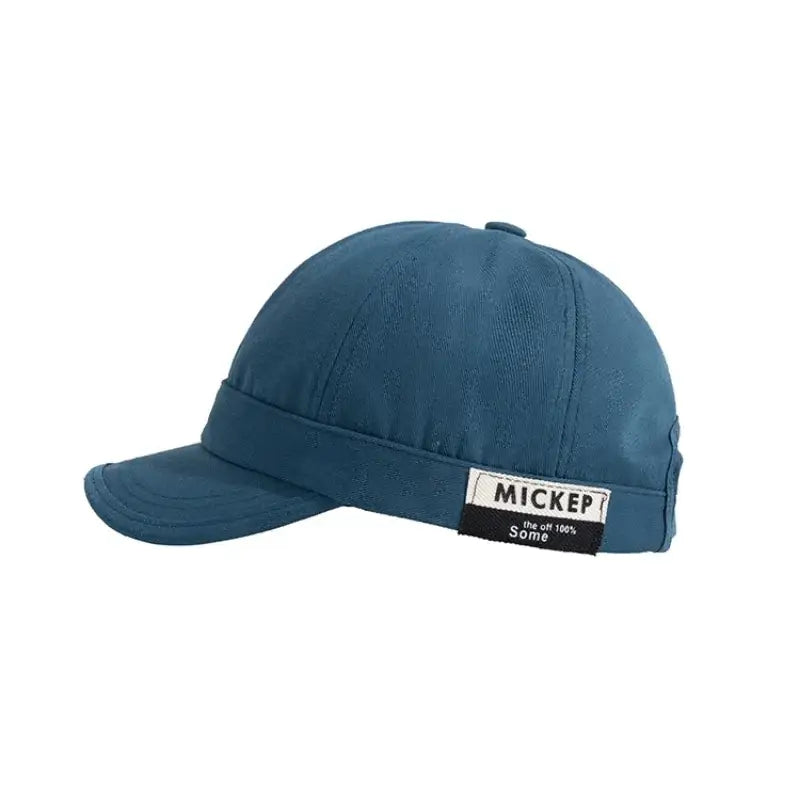 A teal-colored, structured baseball cap with a stitched brim and a branded label on the side.