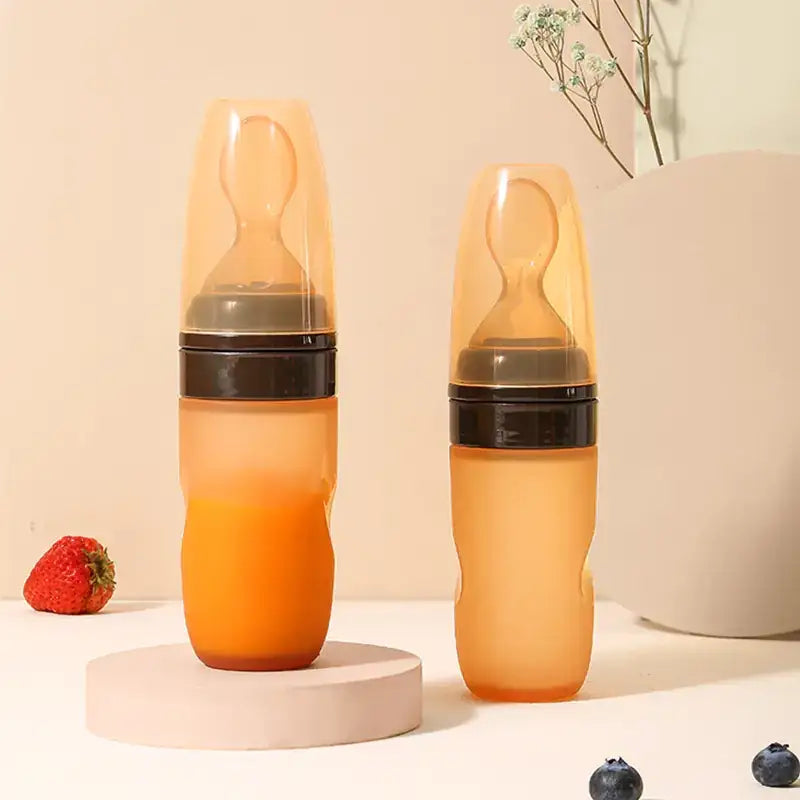 Transparent orange silicone baby bottle with black rubber seal and nipple.