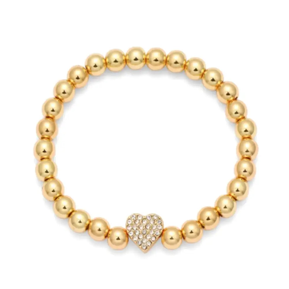 Gold-toned beaded bracelet featuring a central heart charm adorned with sparkling clear crystals.