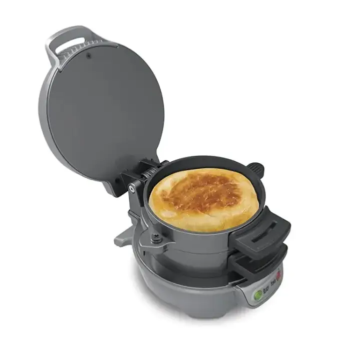 Gray electric pancake maker with a golden-brown pancake cooking inside.