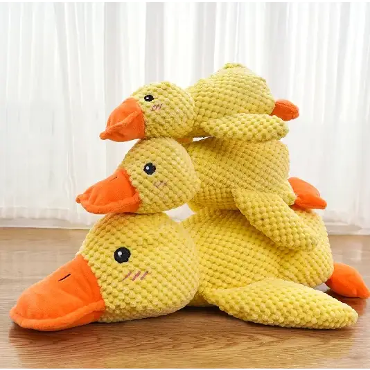 Three yellow corduroy duck plush toys with orange beaks and feet, stacked together.