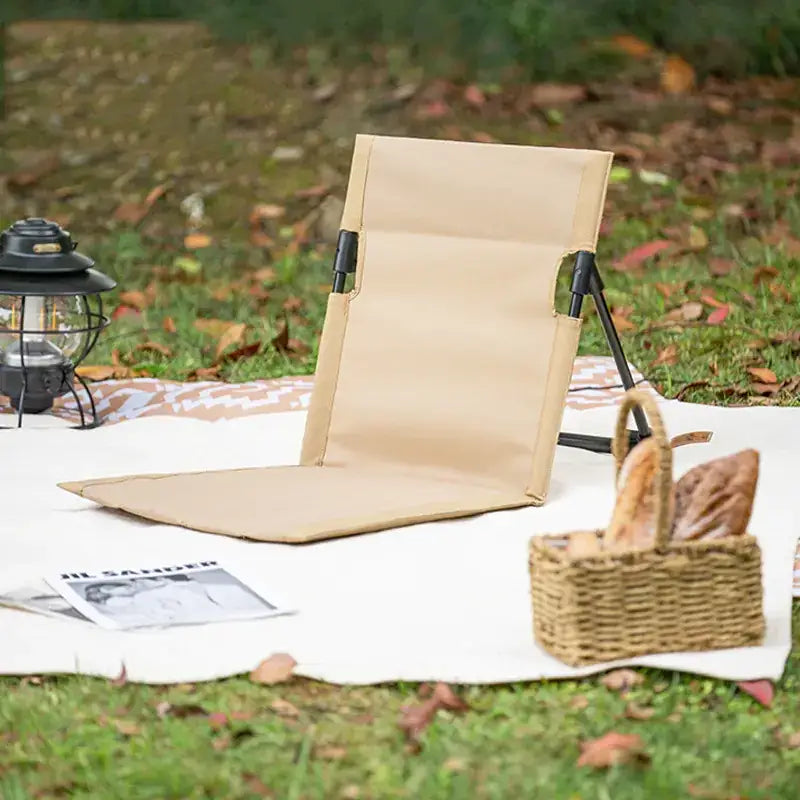 Beige foldable camping chair with black metal frame.