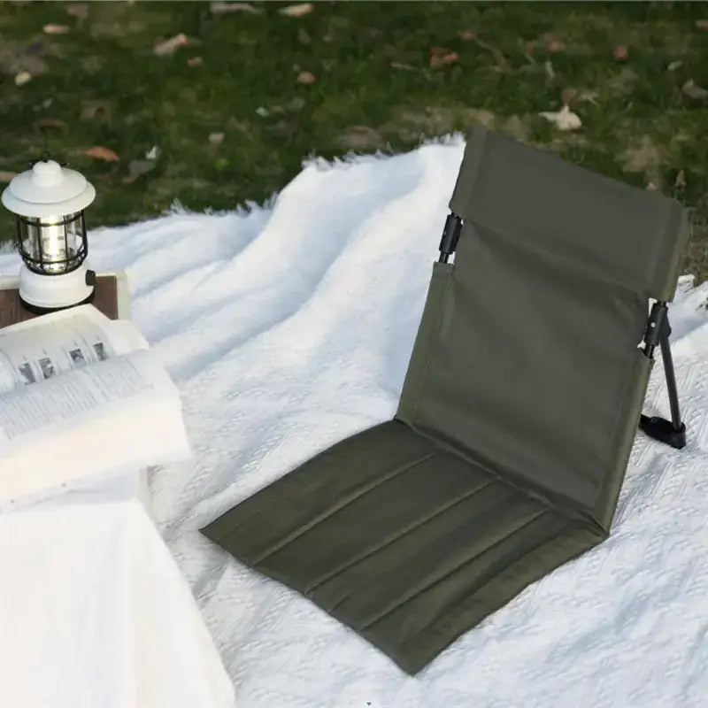 Olive green fabric folding chair with padded seat and backrest, featuring a simple design and black metal frame.